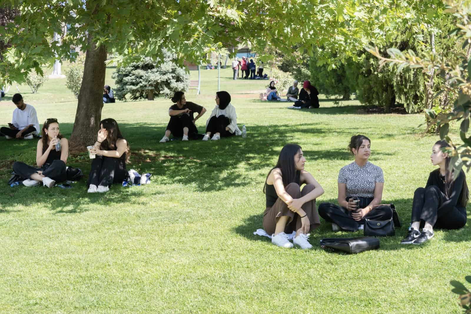 Students relaxing on a green lawn at Hasan Kalyoncu University campus